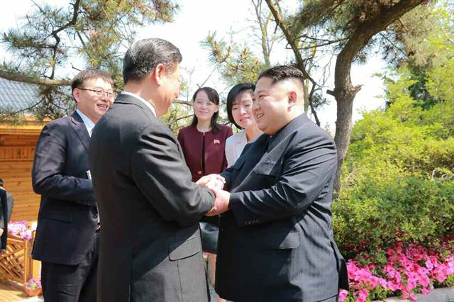 북한 노동당 기관지 노동신문이 9일 게재한 김정은 국무위원장의 중국 랴오닝(遼寧)성 다롄(大連) 방문 사진. 김여정 노동당 제1부부장 등이 지켜보는 가운데 김 위원장이 8일 다롄 동쪽 외곽 해변에 있는 방추이다오(棒槌島) 영빈관에서 시 주석과 만나고 있다. 연합뉴스