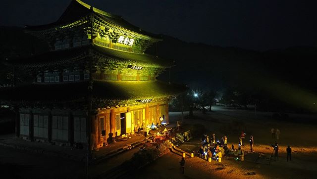 지난달 27일 열린 김제 금산사 ‘마음 쉬는 금요일’ 프로그램에 참여한 참가자들이 미륵전 앞에서 가야금3중주 연주를 감상하고 있다. 금산사 제공