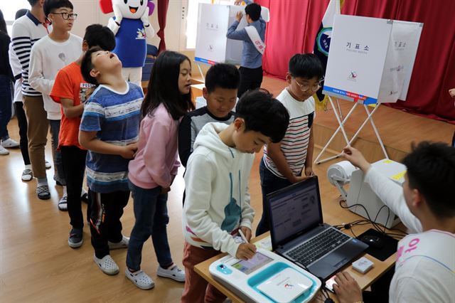 전남 신안선거관리위원회가 지난 14일 국토 최서남단인 가거도 초등학교에서 사전투표 모의체험 행사를 열었다. 미래유권자인 가거도 초·중학교 전교생 14명이 투표 장비를 체험하고 있다. 연합뉴스