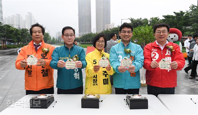 16일 오후 부산진구 송상현 광장에서 ‘6ㆍ13 아름다운 정책선거 희망광장’ 제막식이 열려 참석한 부산시장 예비후보자들이 공약을 적은 뒤 기념촬영을 하고 있다. 이번 행사는 지방선거 출마자들이 허위 사실 유포, 상호비방 등이 아닌 정책과 공약으로 경쟁하는 ‘정책선거’ 결의를 다짐하기 위해 마련됐다.