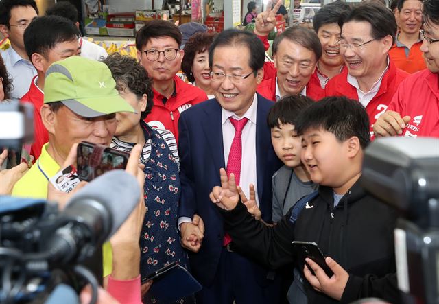 홍준표 자유한국당 대표가 16일 대구시 북구 읍내동 칠곡시장을 찾아 시민들과 기념사진을 찍고 있다. 연합뉴스