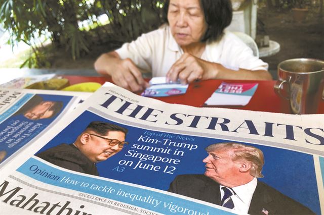 지난 11일 싱가포르의 신문 가판대에 북미 정상회담 싱가포르 개최 소식을 1면에 게재한 ‘더 스트레이츠타임스’신문이 놓여있다. 싱가포르=AP 연합뉴스