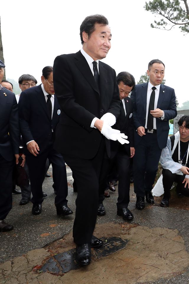 이낙연 국무총리가 18일 오전 광주 북구 망월동 옛 5ㆍ18 묘역에 들어서면서 바닥에 묻힌 전두환 기념비를 밟고 있다. 연합뉴스