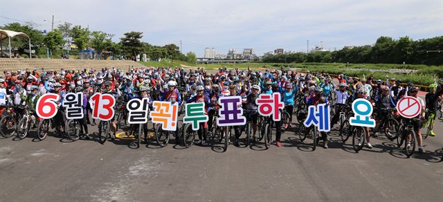 충북자전거연맹 회원들이 청주 무심천 롤러스케이트장에서 자전거 퍼레이드 출발에 앞서 “지방선거에 꼭 참여하자”고 구호를 외치고 있다. 충북도선관위 제공