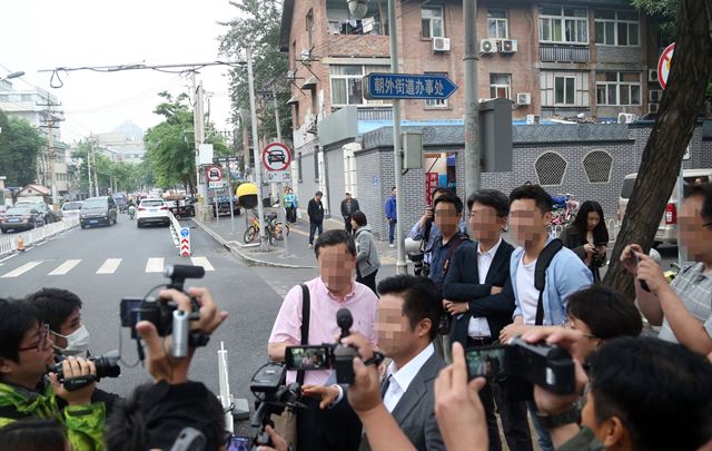 한국 측 취재진에 쏠린 관심. 21일 오후(현지시간) 한국과 일본 등 취재진이 주중 북한대사관 영사부 앞에서 한국 측 풍계리 취재진에게 질문을 하고 있다. 연합뉴스.