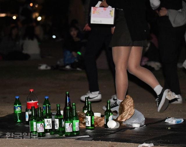 지난 21일 저녁 서울 여의도 한강공원에서 술을 마시는 사람들 주위로 소주병이 가득 놓여있다. 배우한 기자