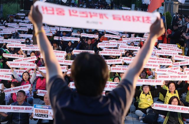 24일 오후 서울 여의도 국민은행 앞에서 민주노총 조합원들이 최저임금 산입범위 개악저지 결의대회를 하고 있다. 연합뉴스