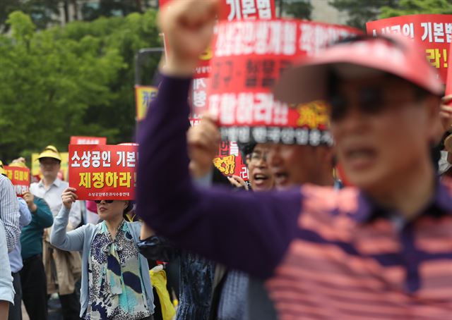 지난 14일 서울 여의도공원에서 열린 소상공인연합회 생존권 보장 결의대회에서 참석자들이 구호를 외치고 있다. 연합뉴스