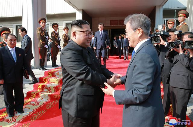 문재인 대통령과 북한 김정은 국무위원장이 26일 오후 판문점 북측 통일각에서 정상회담을 마친 뒤 헤어지며 손을 잡고 있다. 조선중앙통신 연합뉴스