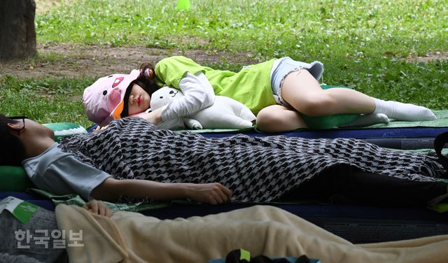 27일 서울 성동구 서울숲에서 '2018 우푸푸 숲속 꿀잠 대회'가 열려 참가자들이 잠을 자고 있다. 홍인기 기자