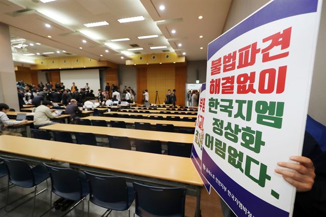 14일 오전 인천시 부평구 한국지엠(GM) 부평공장 홍보관 대강당에서 금속노조 인천지부 한국지엠비정규직지회 노조원들이 자신들의 요구를 적은 손펫말을 들고 서 있다. 이날 이곳에서는 '한국지엠 경영정상화 기자간담회'가 열릴 예정이었지만 한국지엠 비정규직 노조원들의 점거로 일정이 취소됐다. 인천=연합뉴스.