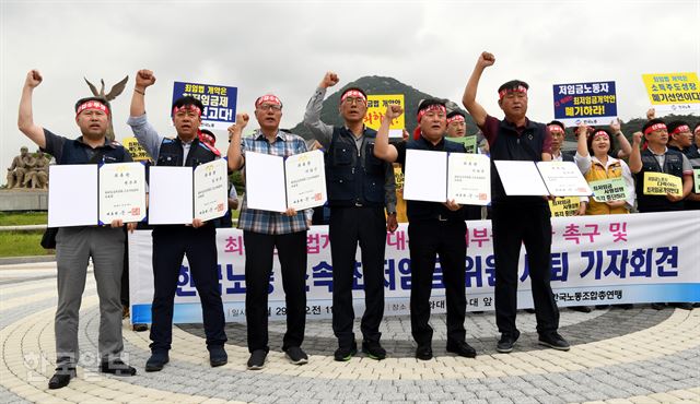 29일 오전 청와대 분수광장 앞에서 한국노총 주최로 열린 대통령 최저임금법 개악안 거부권 행사 촉구 기자회견에서 한국노총 노동자 위원들이 대통령에게 받은 위촉장을 반납하며 국회에서 통과된 최저임금법 개정안에 대해 대통령 거부권 행사를 촉구하는 구호를 외치고 있다.고영권 기자 youngkoh@hankookilbo.com