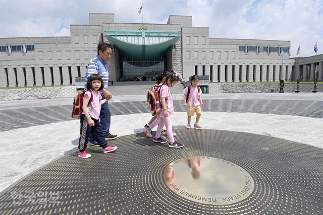 용산구 전쟁기념관 내 재개장한 평화광장에서 기념관을 관람 온 어린이들이 '평화를 원하거든 전쟁을 기억하라(IF YOU WANT PEACE, REMEMBER WAR)'라는 문구가 새겨진 광장 중앙부를 바라보고 있다. 서재훈 기자