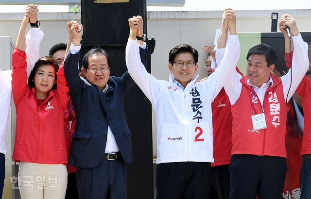 6.13 지방선거 공식선거운동 첫날인 31일 서울역 광장에서 열린 김문수 자유한국당 서울시장 후보 출정식에서 나경원(왼쪽부터) 의원과 홍준표 대표, 김 후보가 손을 들어 인사하고 있다. 고영권 기자 youngkoh@hankookilbo.com