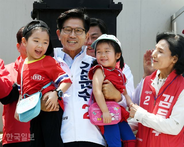 6.13 지방선거 공식선거운동 첫날인 31일 서울역 광장에서 열린 김문수 자유한국당 서울시장 후보 출정식에서 김 후보가 손자 손녀를 안고 있다. 오른쪽은 부인 설난영씨. 고영권 기자 youngkoh@hankookilbo.com