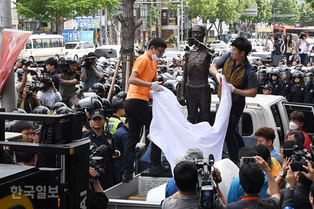 31일 오후 부산 동구청 관계자들이 지게차와 트럭을 이용해 부산 일본총영사관 인근 인도 앞에 놓여 있는 강제징용노동자상을 행정대집행을 통해 철거하고 있다.