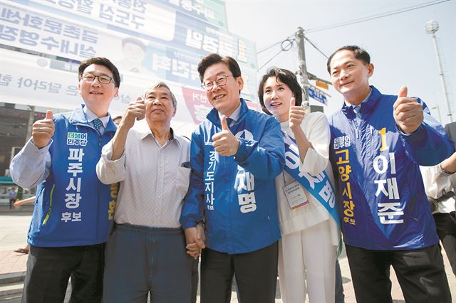 이재명 더불어민주당 경기지사 후보(가운데)가 31일 경기 파주 금촌역 광장에서 엄지손가락을 들어보이며 인사하고 있다. 파주=연합뉴스