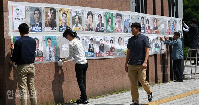 6·13 지방선거 공식선거운동 개시일인 31일 서울 송파구 잠실2동에서 관계자들이 선거벽보를 붙이고 있다. 서재훈 기자