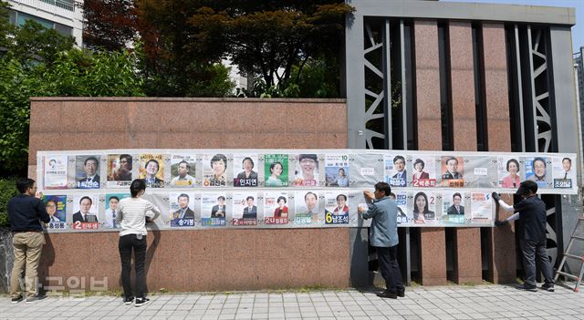 6·13 지방선거 공식선거운동 개시일인 31일 서울 송파구 잠실2동에서 관계자들이 선거벽보를 붙이고 있다. 서재훈 기자