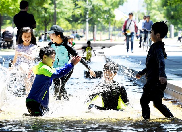 서울 낮 기온이 30도에 이른 1일 서울 여의도 한강공원을 찾은 아이들이 마포대교 아래에서 물놀이하며 더위를 식히고 있다. 김주성 기자