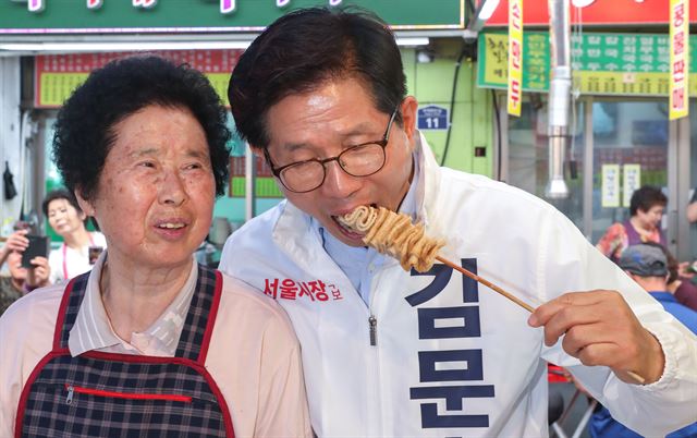 김문수 자유한국당 서울시장 후보가 6.13지방선거 선거운동이 시작된 31일 오후 서울 중구 중앙시장에서 시민들에게 지지를 호소한 뒤 오뎅을 먹고 있다. 뉴스1