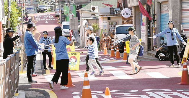 서울 청구초등학교 녹색어머니회 학부모들이 지난달 25일 아이들의 등굣길 안전을 살피고 있다. 초등학교 학부모로 구성된 녹색어머니회는 전국 16개 시도에서 80여만명이 참여하고 있고, 매일(휴일 제외) 2만여명이 등교 시 교통안전 지도를 한다. 김주성 기자