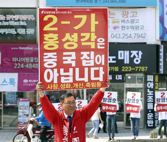 홍성각 자유한국당 청주시의원 후보가 31일 오전 청주시 상당구 청주대교 앞 거리에서 손팻말을 들고 유세하고 있다. 청주=연합뉴스