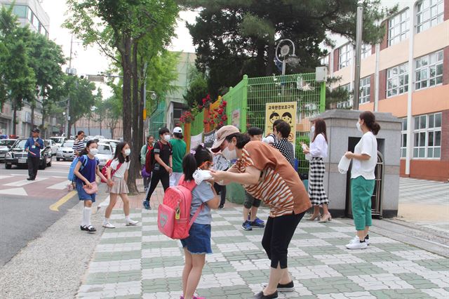 대구 중구 남산초 학생들이 인근 공사장 분진 때문에 마스크를 착용하고 후문으로 등교하고 있다. 김민규기자 whitekmg@hankookilbo.com