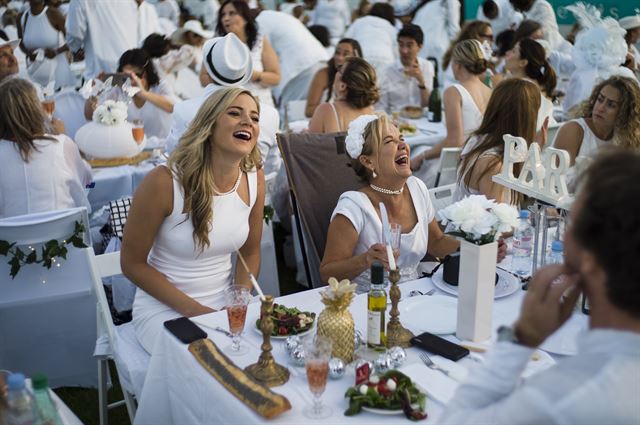 프랑스 파리에서 3일(현지시간) 올해로 30회를 맞는 '디네 앙 블랑(Diner en Blanc)'이 열리고 있는 가운데 하얀 옷을 입고 행사에 참여한 시민들이 저녁을 먹으며 즐거워하고 있다. EPA 연합뉴스