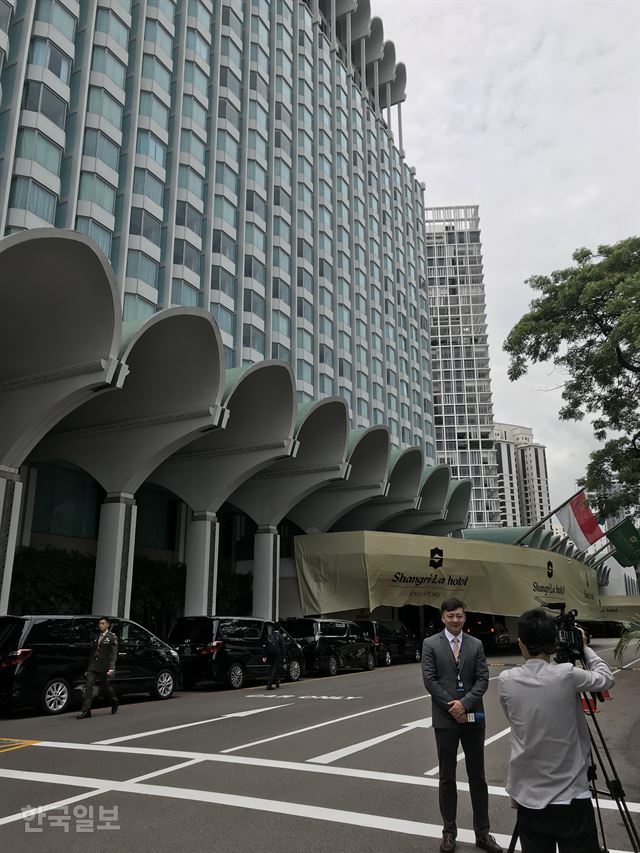 지난 3일 아시아안보회의 당시 샹그릴라 호텔 전경. 차량에서 타고 내리는 인사들이 멀리서는 잘 보이지 않도록 로비 입구 캐노피에 설치된 가림막을 배경으로 한 방송에서 녹화를 하고 있다. 싱가포르 정부는 이 호텔을 포함해 주변 일대를 10일부터 14일까지 북미 정상회담을 위한 특별행사구역으로 지정했다. 싱가포르=정민승 특파원