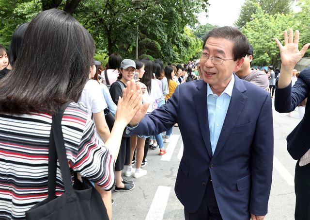 더불어민주당 박원순 서울시장 후보가 4일 서울 숙명여대캠퍼스에서 학생들과 하이파이브를 하고 있다. 연합뉴스