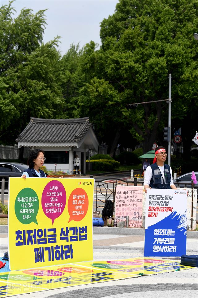 4일 서울 청와대 분수대 앞에서 민주노총의 한 조합원과 김주영(왼쪽) 한국노총 위원장이 최저임금 산입 범위를 확대하는 최저임금법 개정안에 대통령의 거부권 행사를 촉구하며 농성을 하고 있다. 민주노총은 1일부터 농성에 들어갔고, 한국노총도 이날부터 농성에 돌입했다. 김주성 기자