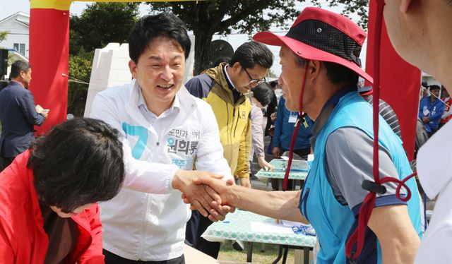 원희룡 제주도지사 무소속 후보가 3일 오전 제주시 장전초등학교 총동문체육대회장을 찾아 악수하며 한 표를 당부하고 있다. 제주=연합뉴스