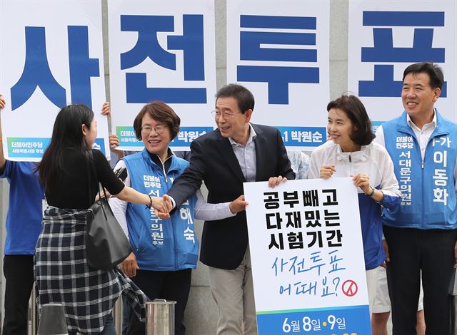 박원순(가운데) 더불어민주당 서울시장 후보가 7일 오전 서울 서대문구 이화여대 앞에서 '잘 보고, 잘 찍고!' 사전투표 독려 캠페인을 하던 중 학생과 악수하고 있다. 연합뉴스