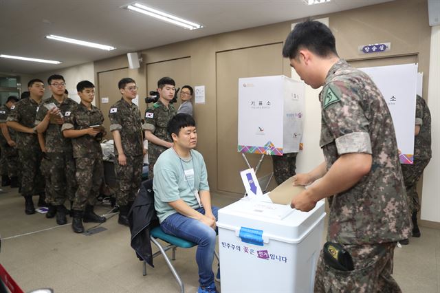 8일 오전 부산 해운대구 우1동 행정복지센터에 마련된 사전투표소에서 육군 53사단 장병들이 투표를 하고자 줄을 서기다리고 있다. 연합뉴스