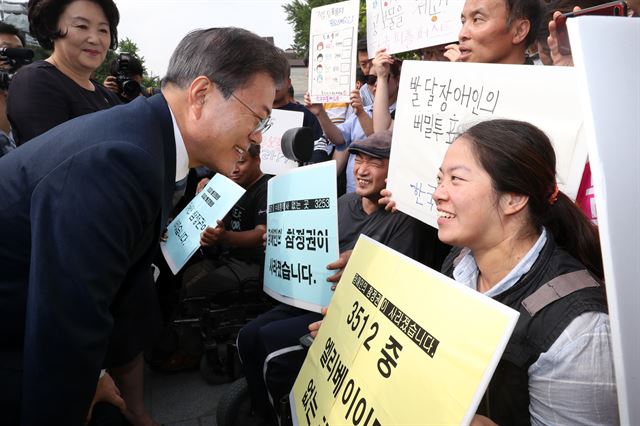 문재인 대통령과 김정숙 여사가 8일 오전 서울 종로구 청와대 인근 한 투표소에서 6·13 지방선거 및 국회의원 재보궐선거 사전투표를 마치고 장애인 참정권을 요구하는 장애인단체 회원들과 대화를 나누고 있다. 한국일보