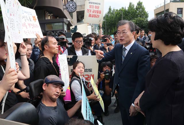 문재인 대통령이 8일 서울 종로구 삼청동주민센터에서 사전 투표를 한뒤 참정권을 보장 시위를 벌이는 장애인단체를 만나고 있다. 한국일보