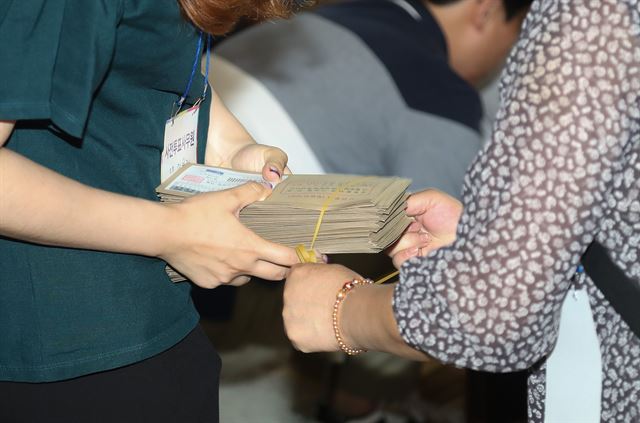 제7회 전국동시지방선거 및 국회의원 재ㆍ보궐선거 사전투표 마지막 날인 9일 서울역에 마련된 사전투표소에서 투표관리관과 투표사무원들이 투표 봉투를 분류하고 있다. 연합뉴스