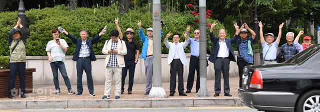 자유한국당 김문수 서울시장 후보가 11일 서울 목동에서 거리유세를 하는 동안 도로 건너편에서 중년의 시민들이 손을 들어 환호하고 있다. 오대근 기자 inliner@hankookilbo.com