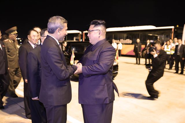 김정은 북한 국무위원장이 12일 오후 역사적인 북미 정상회담을 마친 후 창이국제공항에 도착해 이륙 전 싱가포르의 비비안 발라크리쉬난 외무장관과 악수하고 있다. 싱가포르 통신정보부 제공=연합뉴스