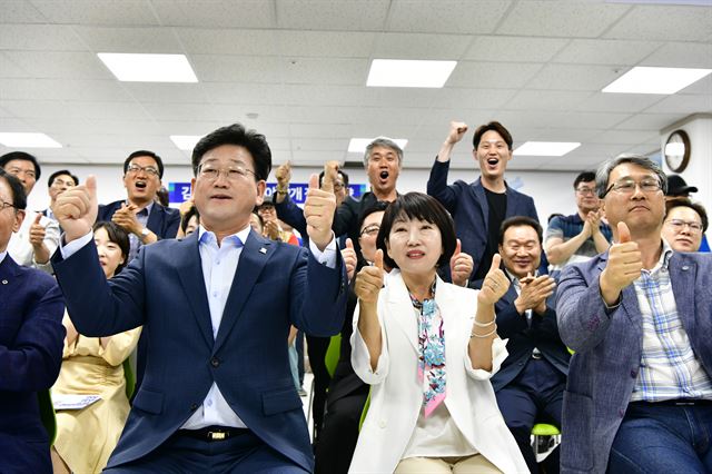 김정호 더불어민주당 김해을 국회의원 보궐선거 후보가 13일 경남 김해시 선거사무실에서 아내 김기영씨와 출구조사 결과 방송을 보며 환호하고 있다. 뉴스1