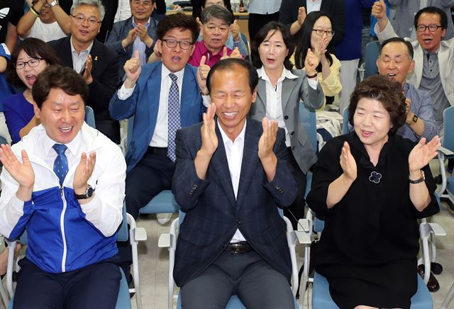 더불어민주당 최문순 강원도지사 후보(가운데)가 13일 오후 강원 춘천시 선거사무실에서 지지자들과 방송사 출구조사 결과를 지켜보며 박수를 치고 있다. 연합뉴스