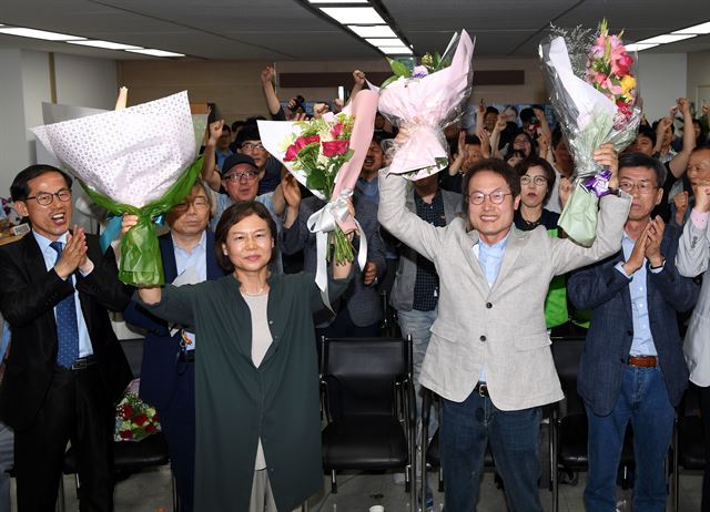 조희연 서울시 교육감 후보자가 13일 오후 서대문구 충정빌딩 캠프에서 당선을 확정한 후 손을 들어 인사하고 있다.왼쪽은 부인 진희숙씨.고영권 기자 youngkoh@hankookilbo.com