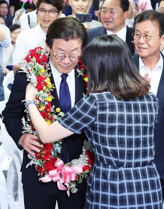 더불어민주당 이재명 경기도지사 후보가 13일 오후 경기도 수원시 팔달구 선거사무소에서 당선이 확실시되자 지지자로부터 꽃목걸이를 받고 있다. 연합뉴스