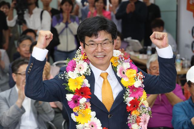 개표 과정에서 김광수 제주도교육감 후보와 접전을 벌인 이석문 당선인이 14일 새벽 제주시 연동 자신의 선거사무소에서 당선이 유력해지자 지지자들로부터 꽃목걸이를 받아걸고 포즈를 취하고 있다. 연합뉴스.