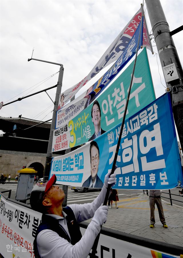 지방선거가 끝난 14일 서울 종로구청 직원들이 흥인지문 인근에 붙은 현수막을 수거하고 있다. 서재훈 기자