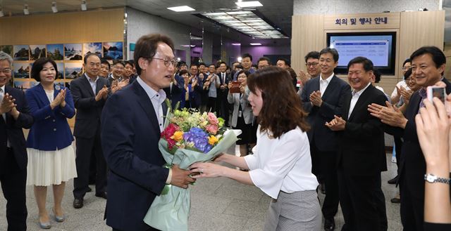 조희연 서울시교육감 당선인이 14일 오전 6ㆍ13 지방선거에서 재선에 성공한 후 종로구 서울시교육청에 첫 출근 해 입구에서 직원으로부터 축하 꽃다발을 받고 있다. 뉴시스