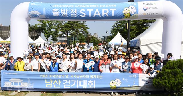 16일 서울 중구 남산백범광장에서 열린 제475회 한국일보 거북이마라톤 '6월은 호국보훈의 달 국가유공자와 함께하는 남산 걷기대회'에서 이준희 한국일보사장(왼쪽 9번째), 심덕섭 국가보훈처 차장(10번째)이 보훈가족과 2017미스코리아를 비롯한 참석자들과 함께 출발신호로 태극기부채를 흔들고 있다 . 신상순 선임기자