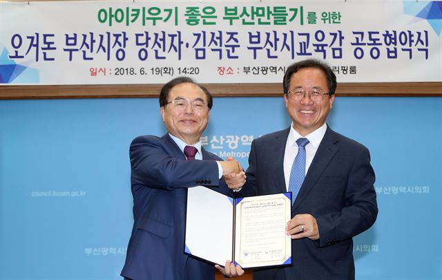 19일 오후 부산시의회 브리핑룸에서 오거돈 부산시장 당선인(왼쪽)과 김석준 부산시교육감 당선인이 아이 키우기 좋은 부산 만들기 공동협약식을 한 뒤 기념촬영을 하고 있다. 연합뉴스