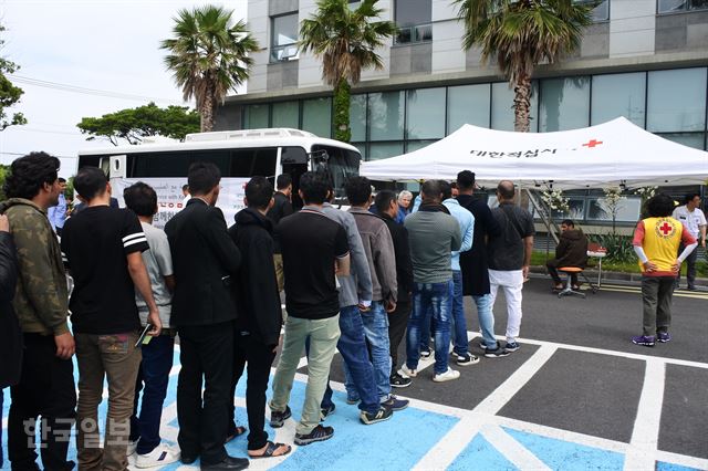 18일 제주 제주시 용담동에 위치한 제주출입국·외국인청 주차장에서 대한적십자사가 제공하는 의료지원을 받기 위해 예멘 난민 신청자들이 줄을 서서 차례를 기다리고 있다. 김영헌 기자.